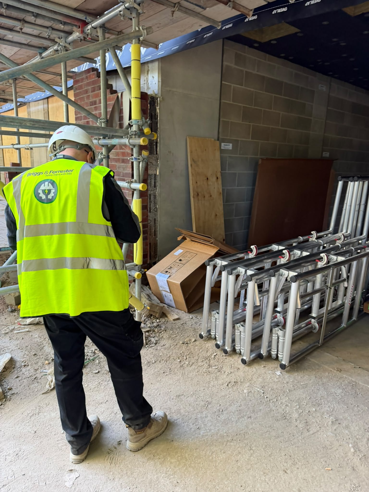 Aluminium scaffold tower frames and components delivered to a commercial construction site, ready for use by contractors.